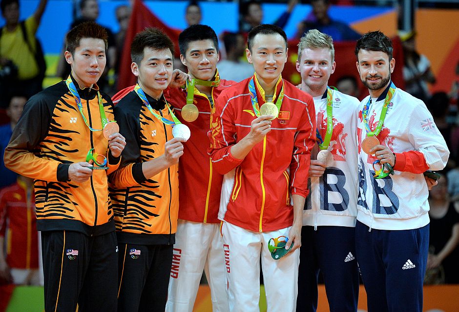 The medal winners for men's badminton doubles gather on the winners' stand at the 2016 Summer Olympics in Rio de Janeiro, Brazil, Friday, Aug. 19, 2016. From left are silver medal winners Goh V Shem and Tan Wee Kiong of Malaysia, gold medal winners Fu Haifeng and Zhang Nan of China, and bronze medal winners Marcus Ellis and Chris Landridge of Great Britain.