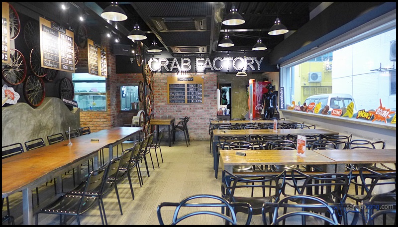 Simple and rustic-style industrial interior with exposed brick wall, utilitarian wooden tables and metal chairs.