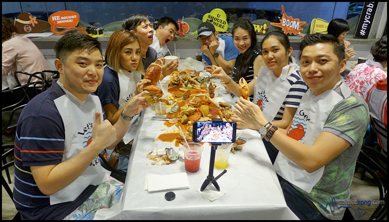 A photo of all the food bloggers in plastic bibs, all ready to dig in the seafood that are poured on the paper-lined table. It's quite a messy affair but that's how you enjoy your crabs and seafood at Crab Factory! 